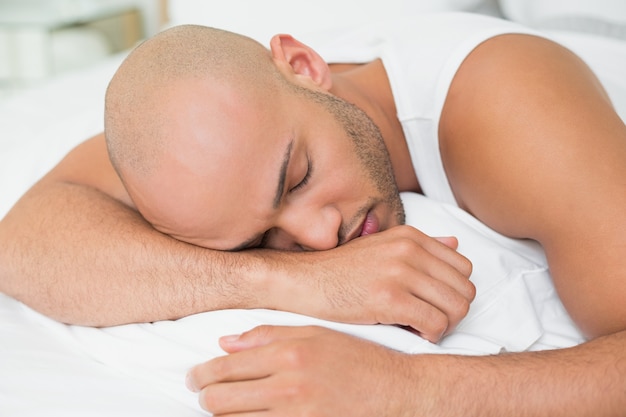 Gros plan d&#39;un jeune homme dormant dans son lit