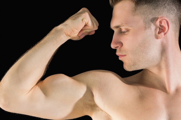 Gros plan de jeune homme flexion des muscles