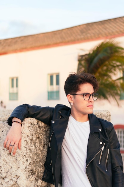 Gros plan d'un jeune homme latino sérieux avec des lunettes en plein air