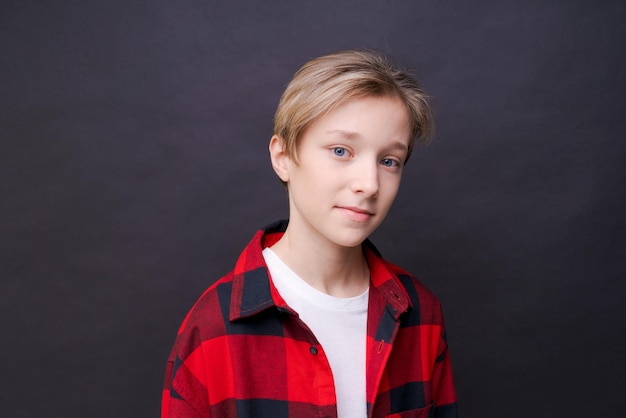 Gros plan jeune homme souriant dans des vêtements décontractés dans une chemise à carreaux rouge posant isolé sur fond studio portrait Personnes émotions sincères concept de mode de vie Copier l'espace pour la copie