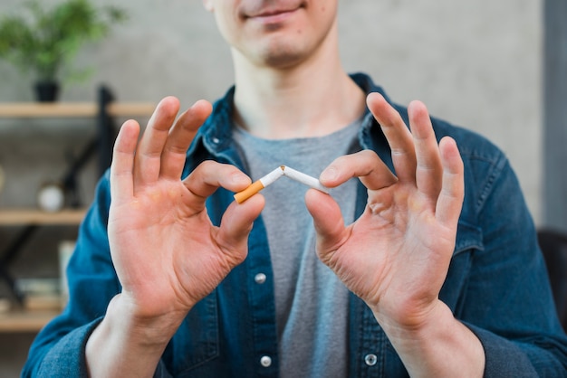 Photo gros plan, de, jeune homme, tenant cigarette brisée