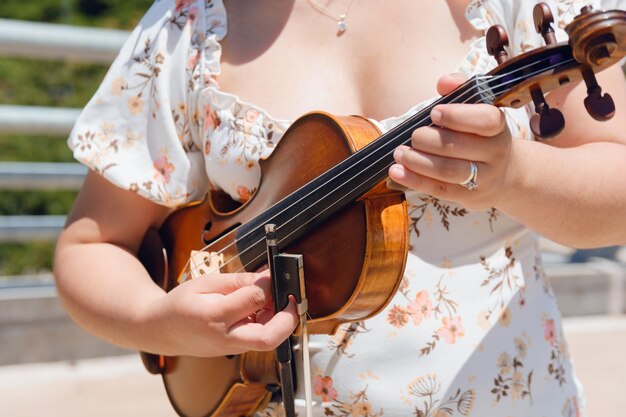 gros plan d'une jeune violoniste inconnue dans la rue avec son violon jouant des cordes