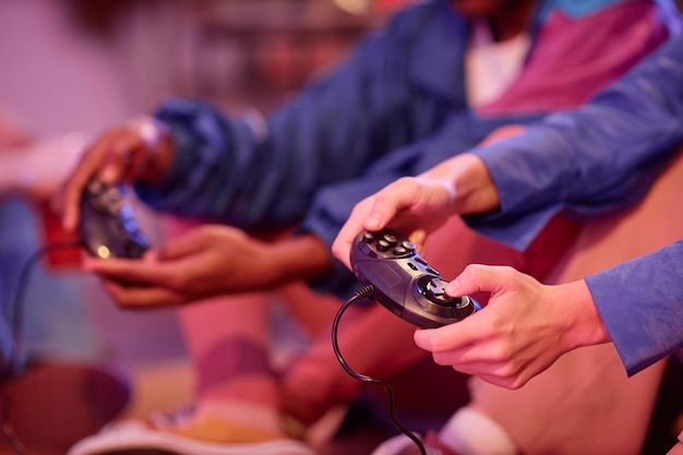 Gros plan sur des jeunes jouant à un jeu vidéo rétro à la lumière du néon