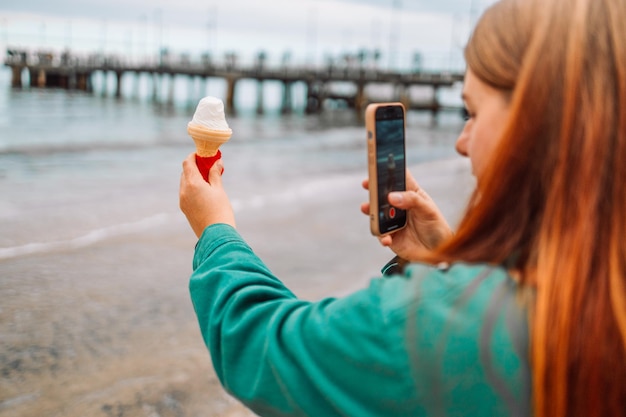 Gros plan sur une jolie jeune fille avec de la glace prenant une photo sur la plage de gdansk voyage tourisme tr