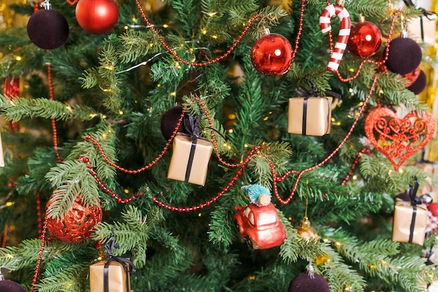 Gros plan des jouets de Noël rouges et colorés accrochés à l'arbre de Noël décoré