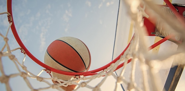Gros plan sur un joueur de basket-ball lance la balle dans le panier de basket-ball