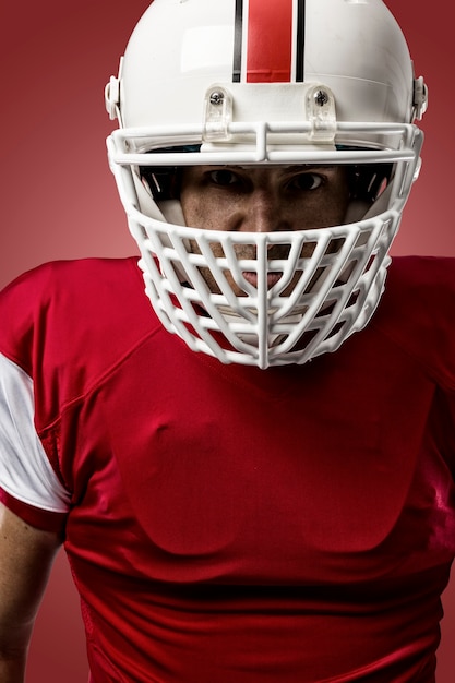 Gros plan d'un joueur de football avec un uniforme rouge sur un mur rouge