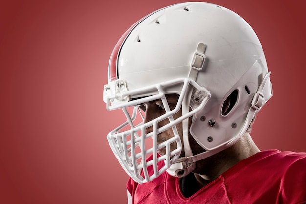 Gros plan d'un joueur de football avec un uniforme rouge sur un mur rouge