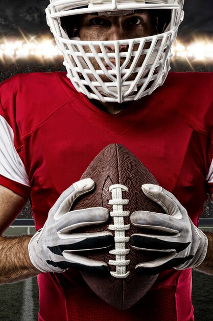 Gros Plan D'un Joueur De Football Avec Un Uniforme Rouge Sur Un Stade.