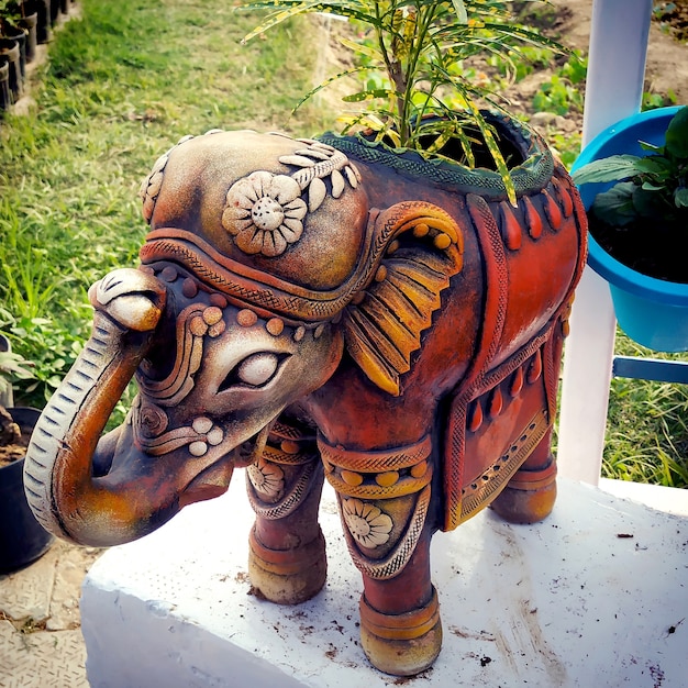 Gros Plan De La Journée D'un Beau Pot De Fleurs En Argile En Forme D'éléphant Avec De Petites Feuilles Vertes Et Des Vignes Poussant à L'intérieur, Sur Un Fond D'asphalte Vert