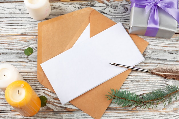 Gros plan de la lettre de Noël écrit sur du papier jaune sur un fond en bois avec des décorations