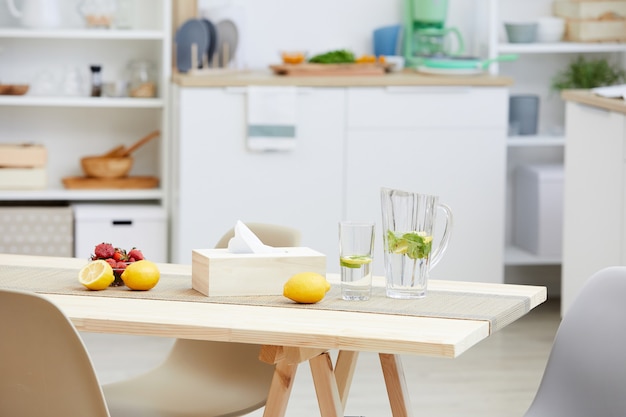 Gros plan de limonade fraîche et de fruits sont sur la table en bois dans la cuisine moderne de la maison