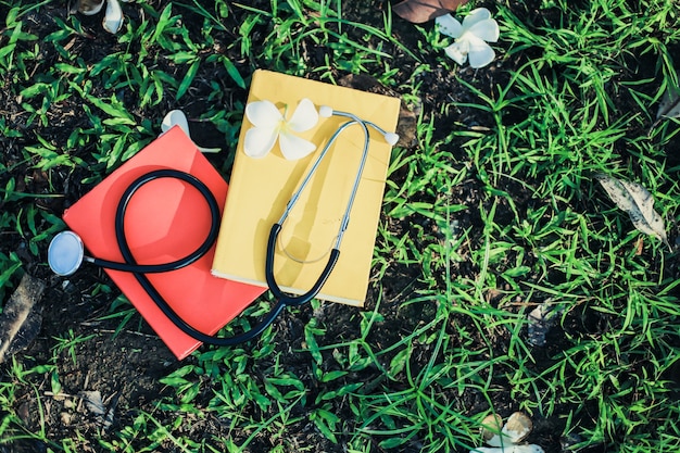 Photo gros plan de livres colorés avec stéthoscope mis sur l'herbe verte