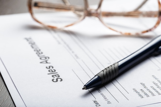 Gros plan de lunettes sur le concept d'entreprise de documents contractuels