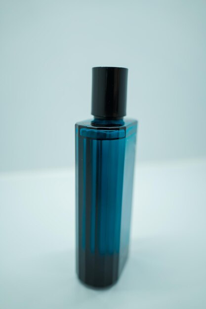 Gros plan sur un luxueux flacon de parfum en cristal bleu parfum masculin isolé sur fond blanc