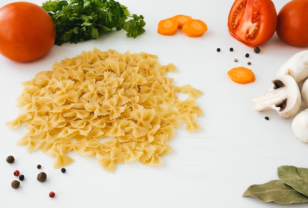 Gros plan de macaroni aux légumes sur bois clair.