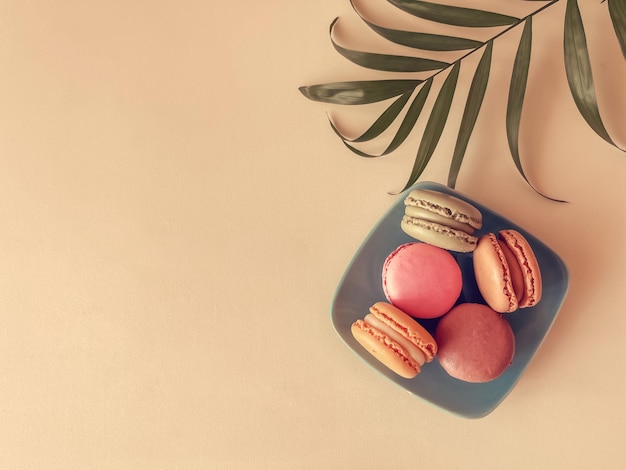 Gros plan de macarons gâteaux de différentes couleurs sur fond de pêche Concept culinaire et de cuisine Savoureux macarons colorés vue de dessus copie espace