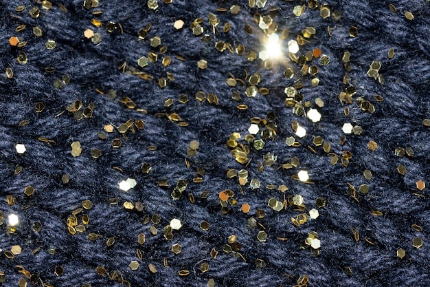 Gros plan macro de pull en laine bleu avec fond de Noël confortable festif de paillettes d'or