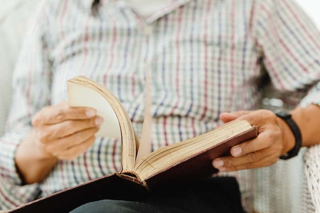 Gros plan main aînée ouvrant la lecture d'un livre