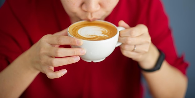 Gros plan main buvant du café chaud avec un temps de détente au travail