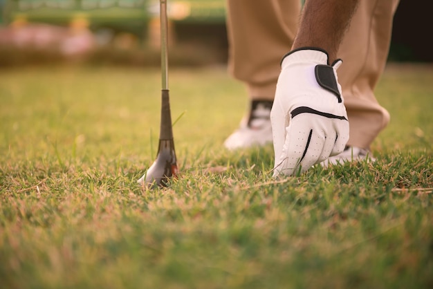 Gros plan de la main du golfeur mis le golf de l'herbe