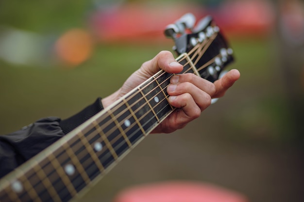 Gros Plan De La Main Du Guitariste Jouant De La Guitare Acoustique.