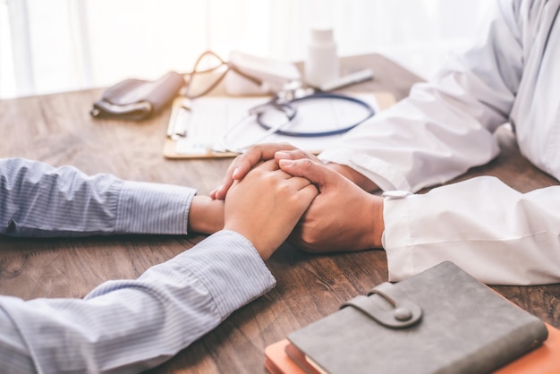 Gros plan sur la main du psychiatre tenant la main du patient. Encourager et réconforter le patient