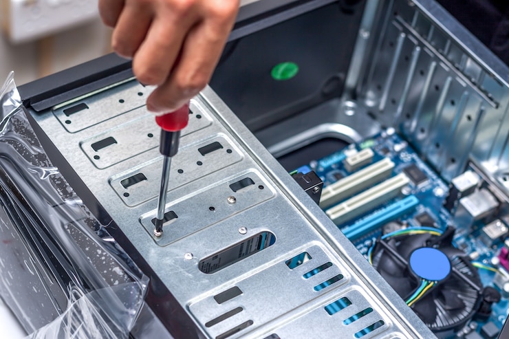 Photo gros plan sur la main du technicien assemblant l'ordinateur personnel