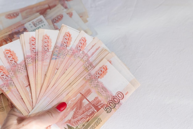 Gros plan de la main féminine avec roubles russes billets en espèces russes de cinq mille roubles finance conce