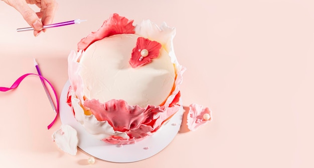 Photo gros plan sur une main de femme décorant un gâteau boulanger ajoute une bougie à un espace de copie de mise au point sélective de gâteau