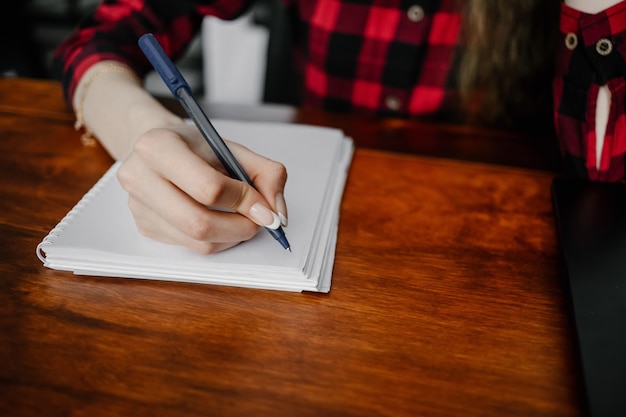 Gros plan de la main de la femme écrit sur papier