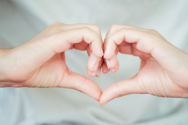 Gros plan de la main d'une femme faisant un symbole en forme de coeur