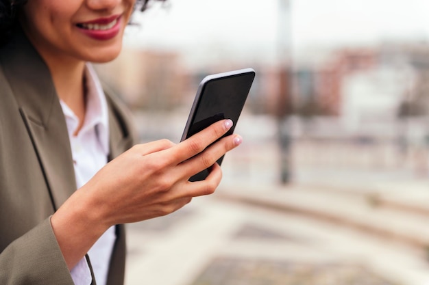 Gros plan d'une main de femme tenant un téléphone intelligent