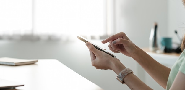 Gros plan sur la main d'une femme utilisant un téléphone, parcourant des applications, lisant de bonnes nouvelles dans un message, une jeune femme heureuse discutant ou faisant des achats en ligne, s'amusant avec un gadget.