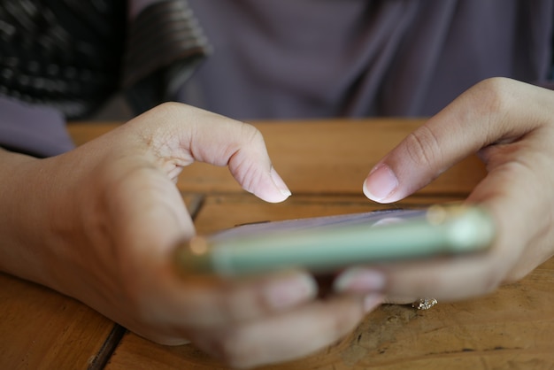 Gros plan de la main des femmes tenant un téléphone intelligent