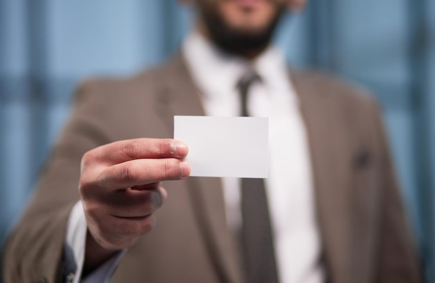 Photo gros plan de la main d'homme d'affaires montrant la carte de visite