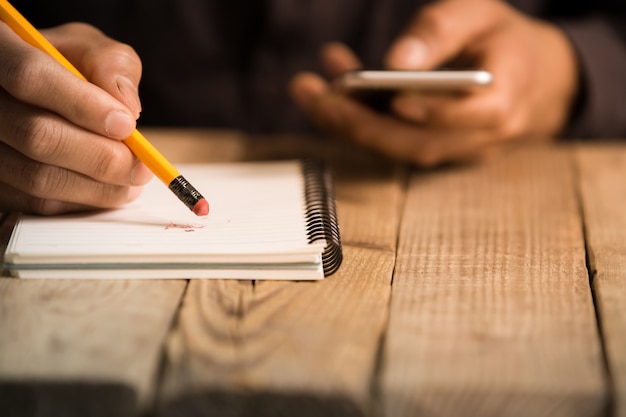 Gros plan sur la main d&#39;un homme écrivant sur papier avec un crayon