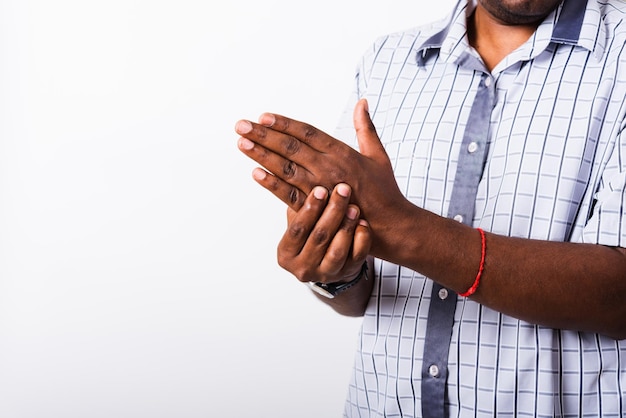 Gros plan sur la main L'homme noir asiatique tient sa blessure à la paume de la main, ressentant de la douleur, prise de vue en studio isolée sur fond blanc. Concept de syndrome de soins de santé et de cabinet médical