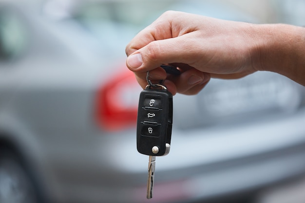 Gros plan de la main de l'homme tenant la clé de voiture