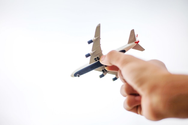 Photo gros plan de la main de l'homme tenant le modèle de jouet d'avion sur sky.transport et concept de voyage.
