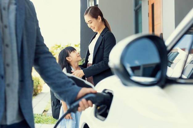 Gros plan sur la main insérez la fiche du chargeur EV progressive dans la voiture EV à ho