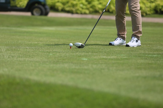 Photo gros plan sur une main masculine tenant un club de golf pour faire un coup