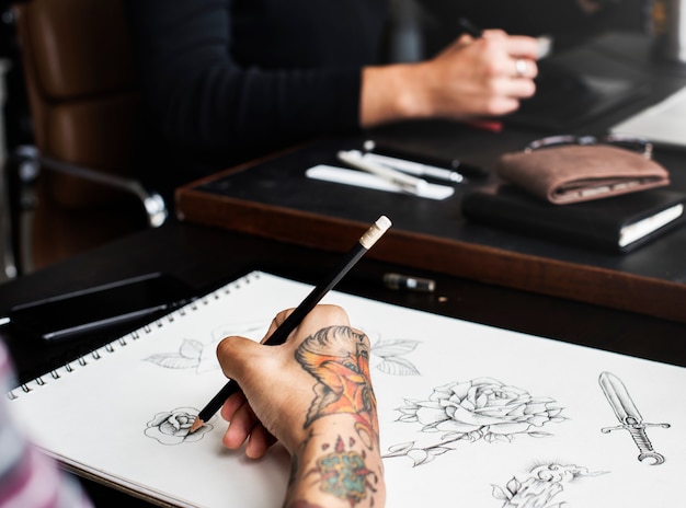 Gros plan de la main tatouée avec des illustrations de dessin