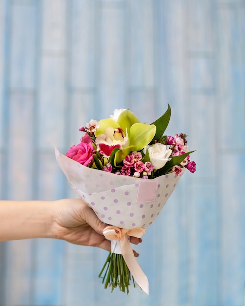 Gros plan sur main tenant le bouquet de fleurs