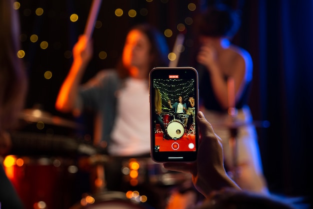 Gros plan main tenant un smartphone au concert