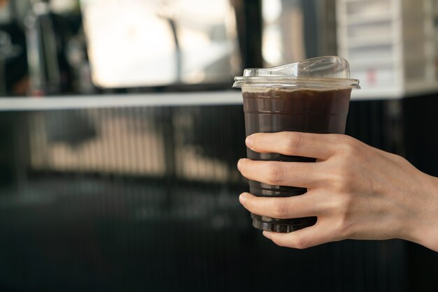 gros plan main tenant une tasse de café noir