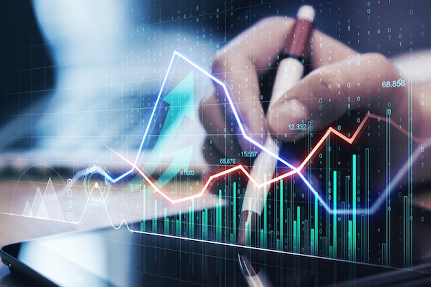Gros plan des mains à l'aide d'un ordinateur portable avec un graphique et des flèches d'affaires brillants créatifs