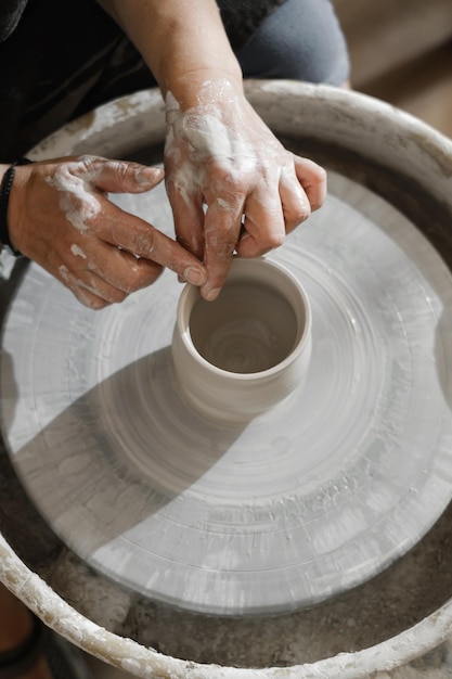 Gros plan des mains à l'atelier de poterie apprendre à faire un bol d'argile