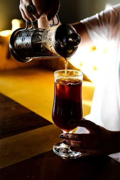 Gros plan des mains barista faire du café au lait