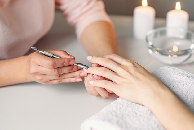 Gros plan des mains de belle femme se manucure dans le salon spa